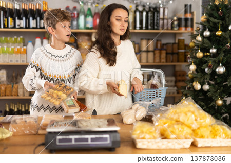Adult woman with son choosing products in grocery store 137878086