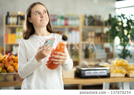 Teenage girl scanning qr code of grapefruit juice 137878254
