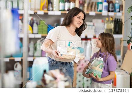 Mother and daughter choose gifts for relatives in home goods store - shampoo, liquid soap and bathroom accessories Mother and daughter choose gifts for relatives in home goods store - shampoo, liquid soap and bathroom accessories 137878354
