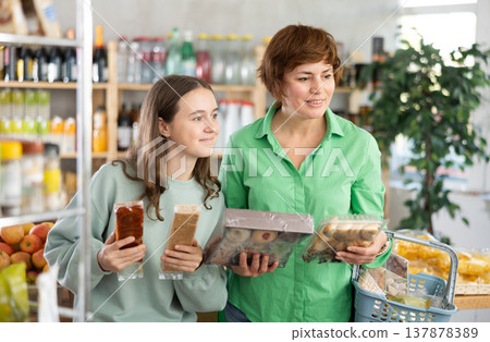 Woman with a child chooses sweets Woman with a child chooses sweets 137878389