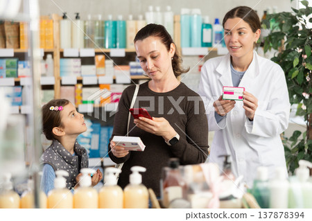 Concerned woman checking medicine safety online at pharmacy Concerned woman checking medicine safety online at pharmacy 137878394