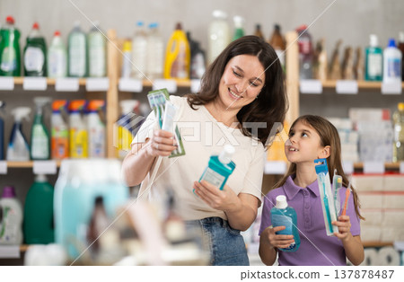 Woman with daughter choosing dental care products Woman with daughter choosing dental care products 137878487