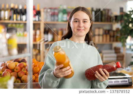 Teenage girl chooses peach and tomato juices 137878552