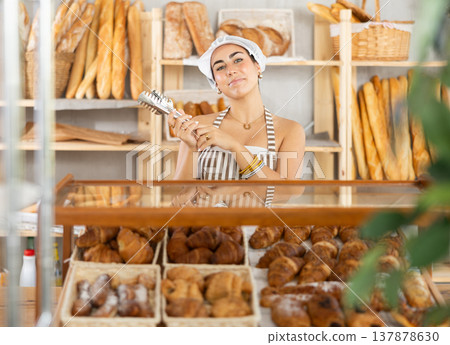 Young saleswoman holding a service clip ready to serve customers Young saleswoman holding a service clip ready to serve customers 137878630