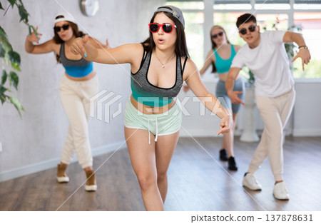 Group of young women and young guy in sunglasses dancing hip hop Group of young women and young guy in sunglasses dancing hip hop 137878631