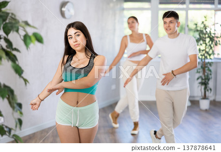 Brunette teenage girl practicing vigorous dance with group in studio 137878641