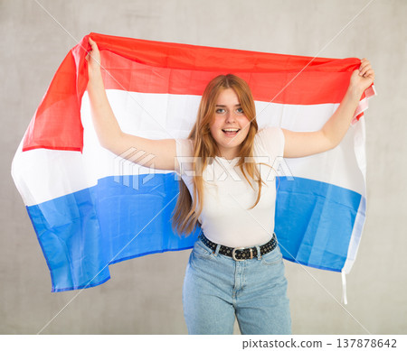 Attractive female student holding Netherlands flag Attractive female student holding Netherlands flag 137878642