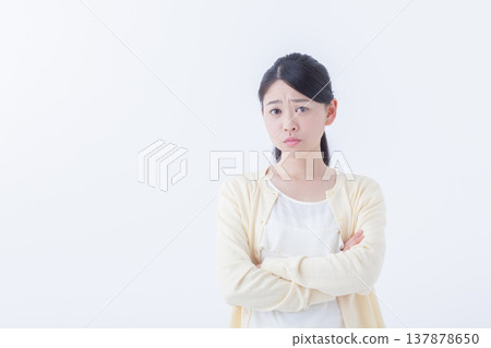一位年輕女子憤怒地雙手交叉抱在胸前。 一位年輕女子憤怒地雙手交叉抱在胸前。 137878650