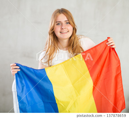 smiling girl in arms raised above head holds canvas of national flag of Romania smiling girl in arms raised above head holds canvas of national flag of Romania 137878659