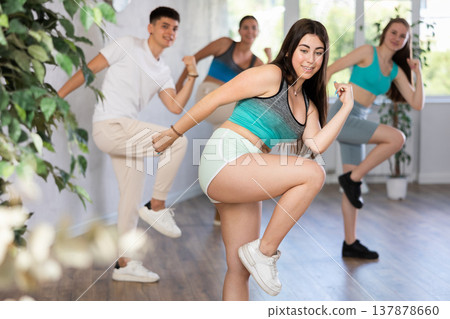 Girl teen perform choreographic exercise and teach energetic waacking dance with friends Girl teen perform choreographic exercise and teach energetic waacking dance with friends 137878660