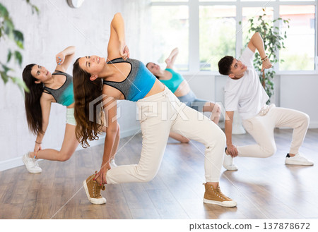 Young girl krumper dancing with group of teenagers in studio Young girl krumper dancing with group of teenagers in studio 137878672