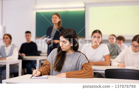 Young girl student diligently studies at school Young girl student diligently studies at school 137878798