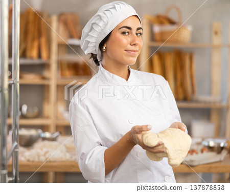 Young female baker with raw dough 137878858