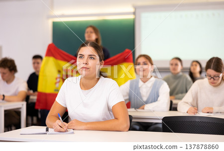Teacher stands behind students with flag of Spain Teacher stands behind students with flag of Spain 137878860