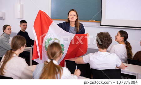 Adult female teacher showing flag of Peru to students 137878894