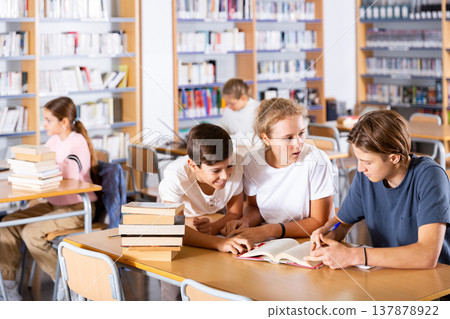 Teenage students working in groups in library 137878922