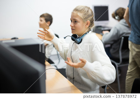 Dissapointed girl at computer table Dissapointed girl at computer table 137878972