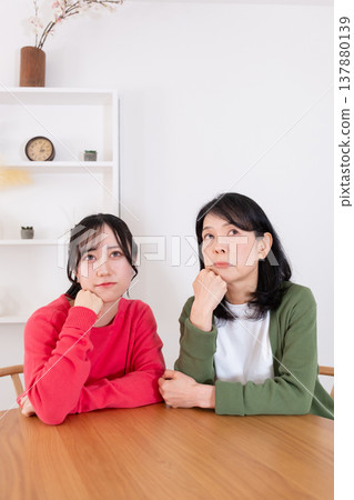 A mother and daughter looking up, lost in thought. A mother and daughter looking up, lost in thought. 137880139