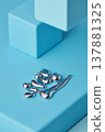 Polished liquid-metal droplets smooth matte cyan blocks in minimal studio composition 137881325