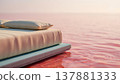 High-end mattress ensemble floating on a tranquil pink saline lake at golden hour 137881333