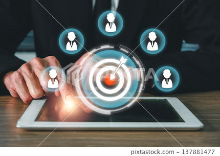Businessman interacting with digital tablet, showcasing target and network icons for CRM and marketing strategy. Businessman interacting with digital tablet, showcasing target and network icons for CRM and marketing strategy. 137881477