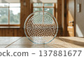 A clear glass dish filled with hundreds of small white spherical objects on a wooden table 137881677