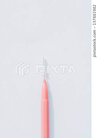 Interdental brush close up on light blue background, minimal oral hygiene concept with copy space Interdental brush close up on light blue background, minimal oral hygiene concept with copy space 137881982