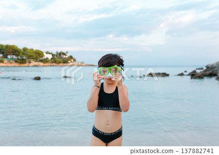 portrait of a girl with big swimming goggles standing on a beach portrait of a girl with big swimming goggles standing on a beach 137882741