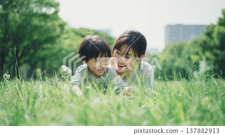 Parent and child lying on the grass 137882913