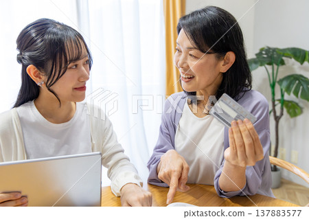 Mother girl doing online shopping Mother girl doing online shopping 137883577