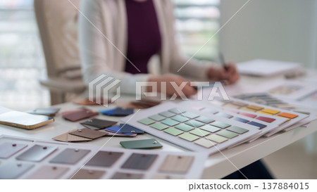 Adult professional designer hands select color palettes material swatches using smartphone for interior architecture project development modern studio office workspace desk Adult professional designer hands select color palettes material swatches using smartphone for interior architecture project development modern studio office workspace desk 137884015