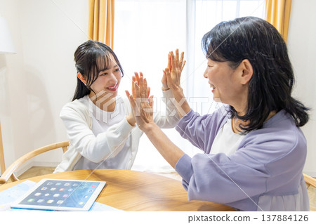 Mother and daughter high-five 137884126