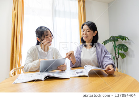 Mother and daughter looking at a catalog Mother and daughter looking at a catalog 137884404