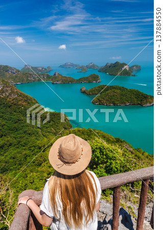 Young woman at viewpoint in Ang Thong National Marine Park overlooking turquoise sea and tropical islands Young woman at viewpoint in Ang Thong National Marine Park overlooking turquoise sea and tropical islands 137884550