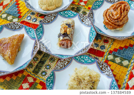 Arabic-style fabrics with mirror-work embroidery and traditional sweets such as baklava. 137884589