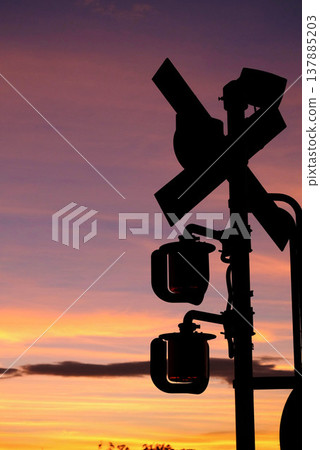 夕陽西下,鐵路道口的輪廓清晰可見:暮色中的鐵路景象。 夕陽西下,鐵路道口的輪廓清晰可見:暮色中的鐵路景象。 137885203