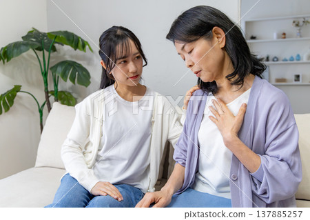 A mother who is unwell and her worried daughter A mother who is unwell and her worried daughter 137885257