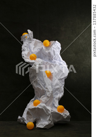 Still life with crumpled paper and orange balloons Still life with crumpled paper and orange balloons 137885432