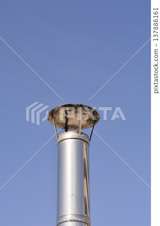 Modern Steel Chimney with Rain Cap against Blue Sky Modern Steel Chimney with Rain Cap against Blue Sky 137886161