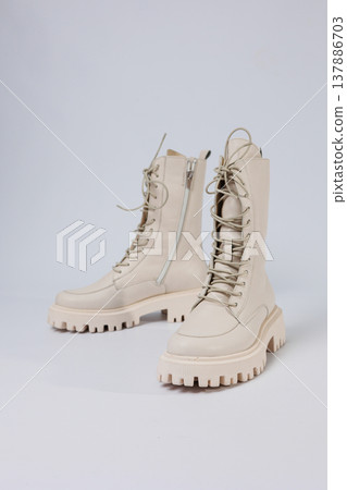 Women's white winter boots with fur with thick soles and laces. Advertising of the new collection of women's shoes 2022 Women's white winter boots with fur with thick soles and laces. Advertising of the new collection of women's shoes 2022 137886703