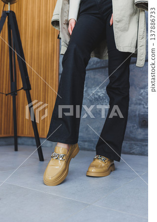 Woman's legs in trousers and beige leather shoes Woman's legs in trousers and beige leather shoes 137886733
