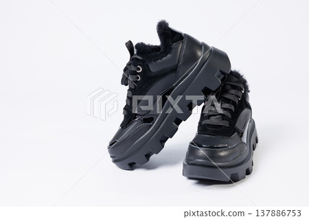 Women's fashionable black leather sneakers with fur on a white background. New collection of women's winter sneakers 2022 Women's fashionable black leather sneakers with fur on a white background. New collection of women's winter sneakers 2022 137886753