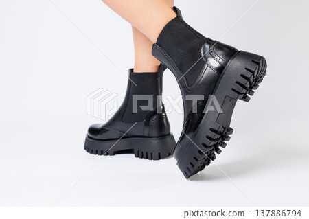 New collection of women's shoes spring 2022. girl's legs in new shoes. Legs in black boots. Low running boots made of genuine leather New collection of women's shoes spring 2022. girl's legs in new shoes. Legs in black boots. Low running boots made of genuine leather 137886794