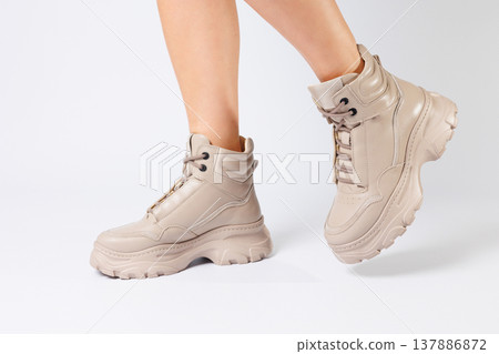 Female legs in beige leather shoes from the new collection on a white background female legs in fashionable shoes made of eco-leather spring 2022. Female legs in beige leather shoes from the new collection on a white background female legs in fashionable shoes made of eco-leather spring 2022. 137886872