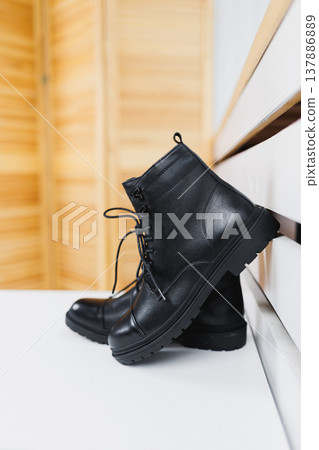 Black shoes lie on the floor. Winter black leather women's shoes. Black shoes lie on the floor. Winter black leather women's shoes. 137886889