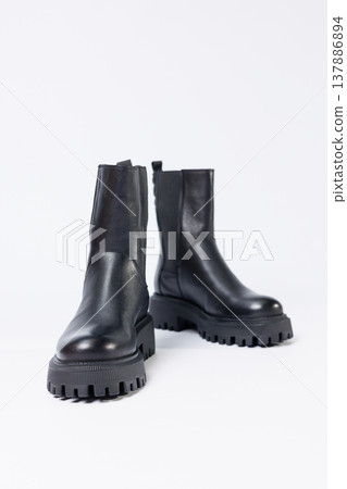 Women's shoes on a white background. Close-up of women's black leather chelsea boots on a white background. Shoes for the city. Fashion, design and footwear concept. Women's shoes on a white background. Close-up of women's black leather chelsea boots on a white background. Shoes for the city. Fashion, design and footwear concept. 137886894