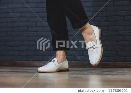 Close-up female legs in black trousers and leather beige moccasins. New spring-summer collection of women's leather shoes 2022 137886901