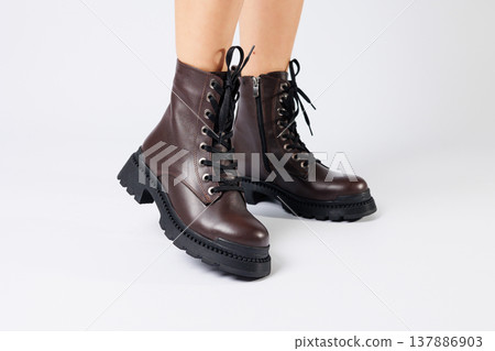 Women's brown spring boots made of genuine leather on a woman's leg. New collection of women's boots 2022 Women's brown spring boots made of genuine leather on a woman's leg. New collection of women's boots 2022 137886903