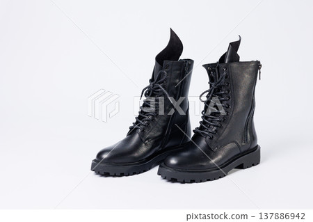 Black women's leather lace-up boots from the new collection on a white background from leather autumn-winter 2022. Boots close-up Black women's leather lace-up boots from the new collection on a white background from leather autumn-winter 2022. Boots close-up 137886942