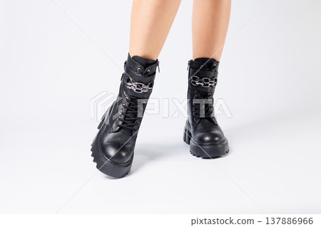 Legs of a woman in black leather boots from a new collection on a white background, legs of a girl in fashionable leather boots spring 2022. Legs of a woman in black leather boots from a new collection on a white background, legs of a girl in fashionable leather boots spring 2022. 137886966